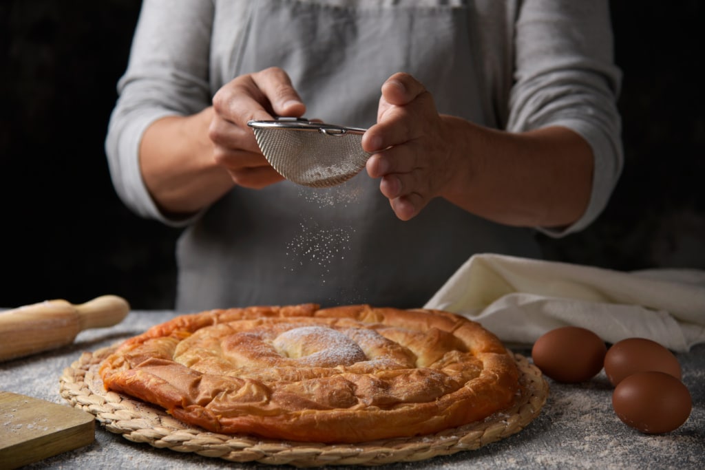 Puderzucker über Schmalzgebäck ensaimada gestreut