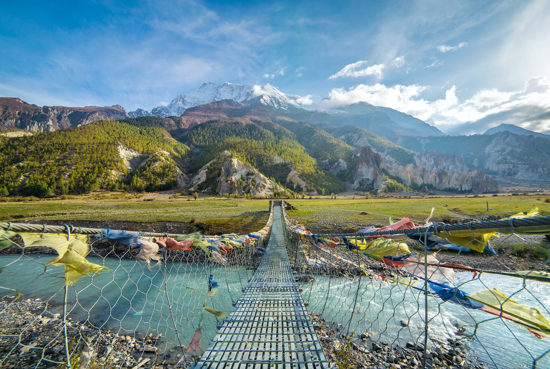 Gebetsflaggen schmücken eine Brücke in nepalesischer Landschaft