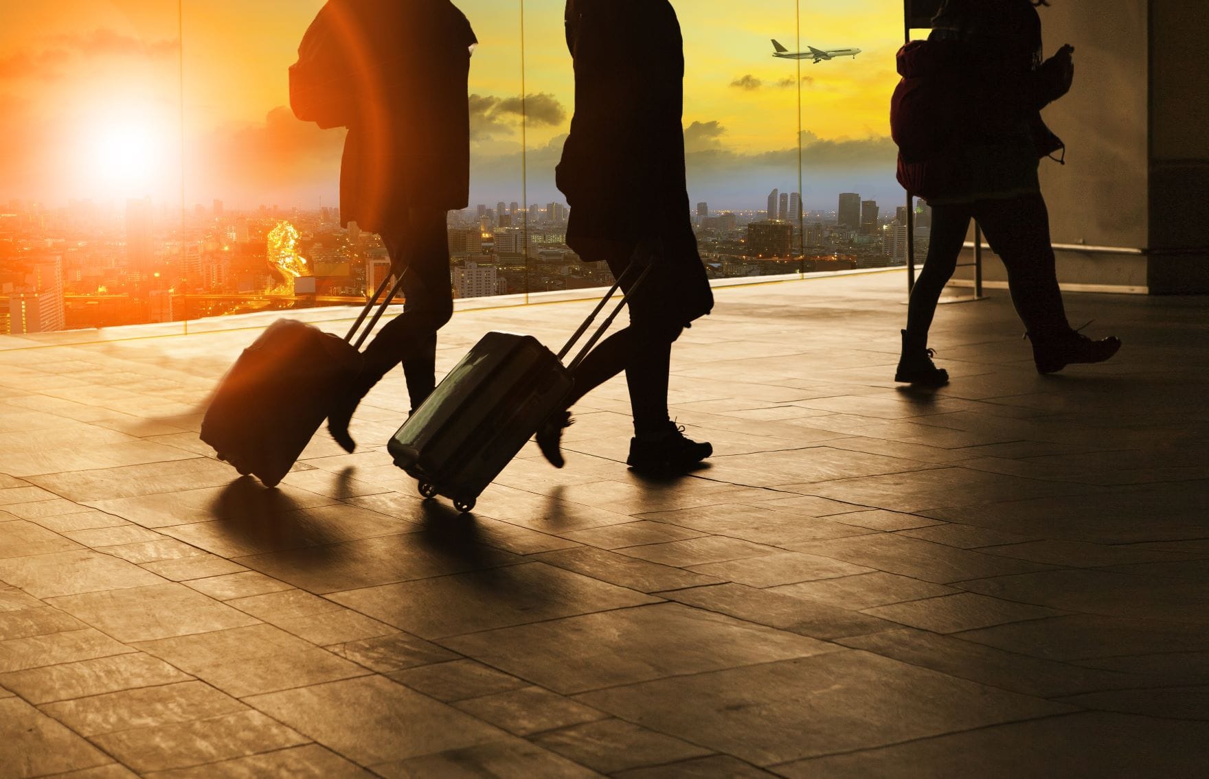 Flugreisende mit Rollkoffer bei Ankunft im Flughafen