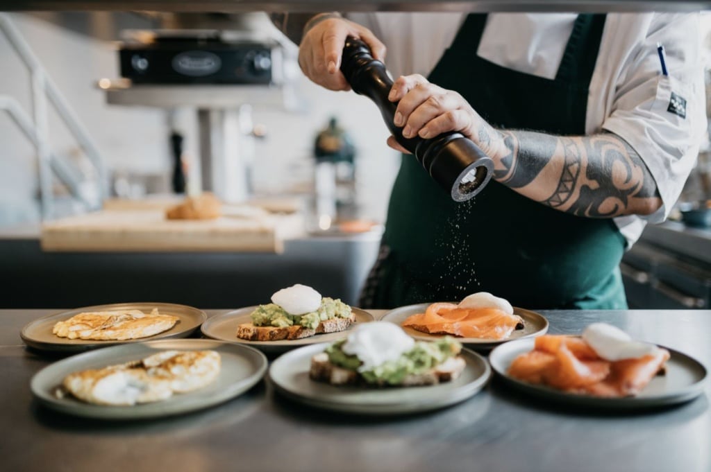 Koch malt Pfeffer über die Mahlzeiten des Restaurants Vessel im Boat & Co