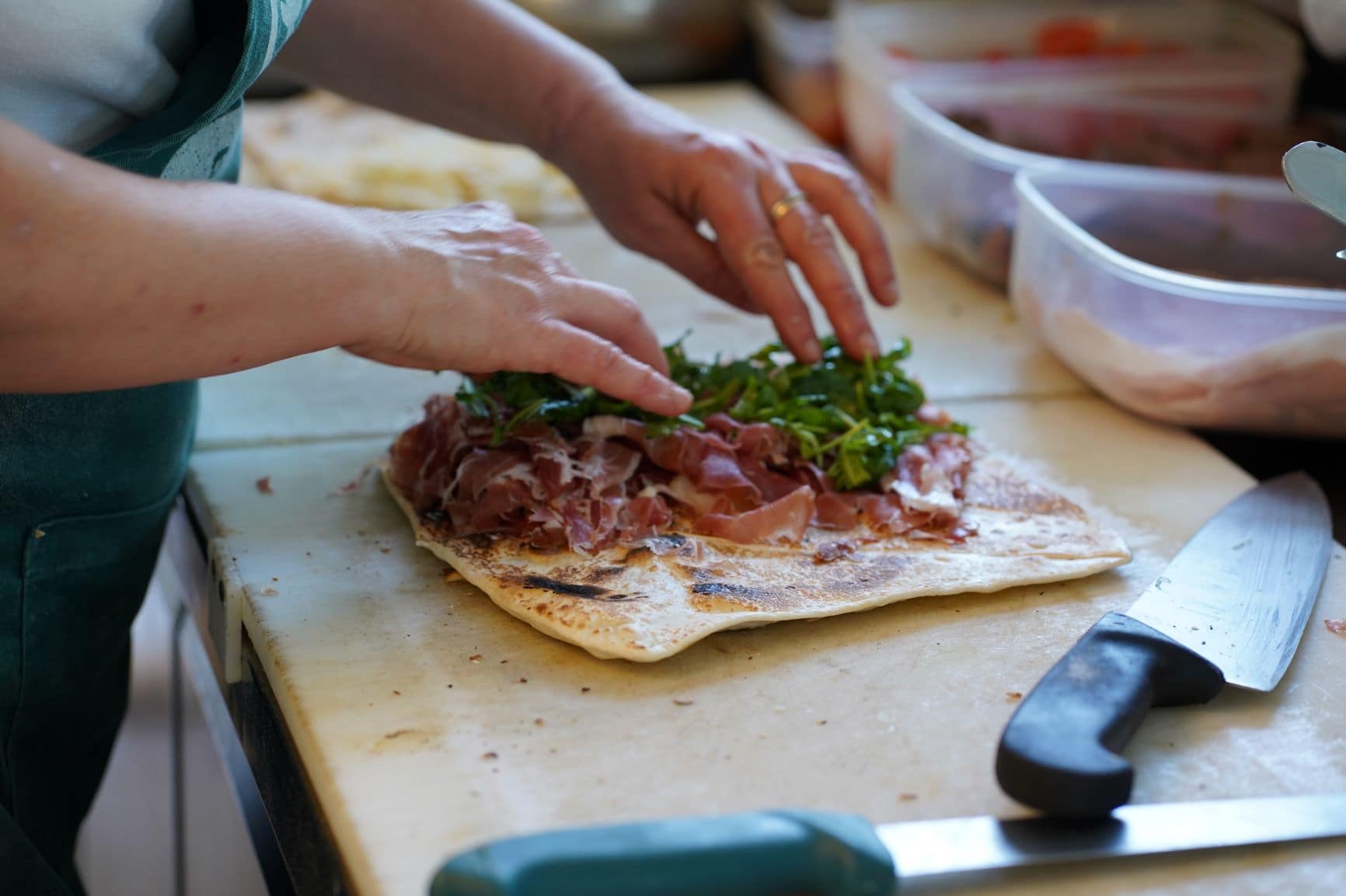 Frau bereitet mit Händen Piadina zu