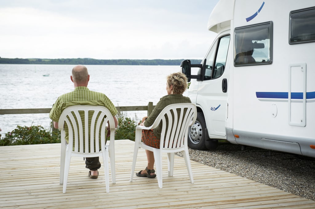 Älteres Ehepaar sitzt auf Campingstühlen am Mariager Camping