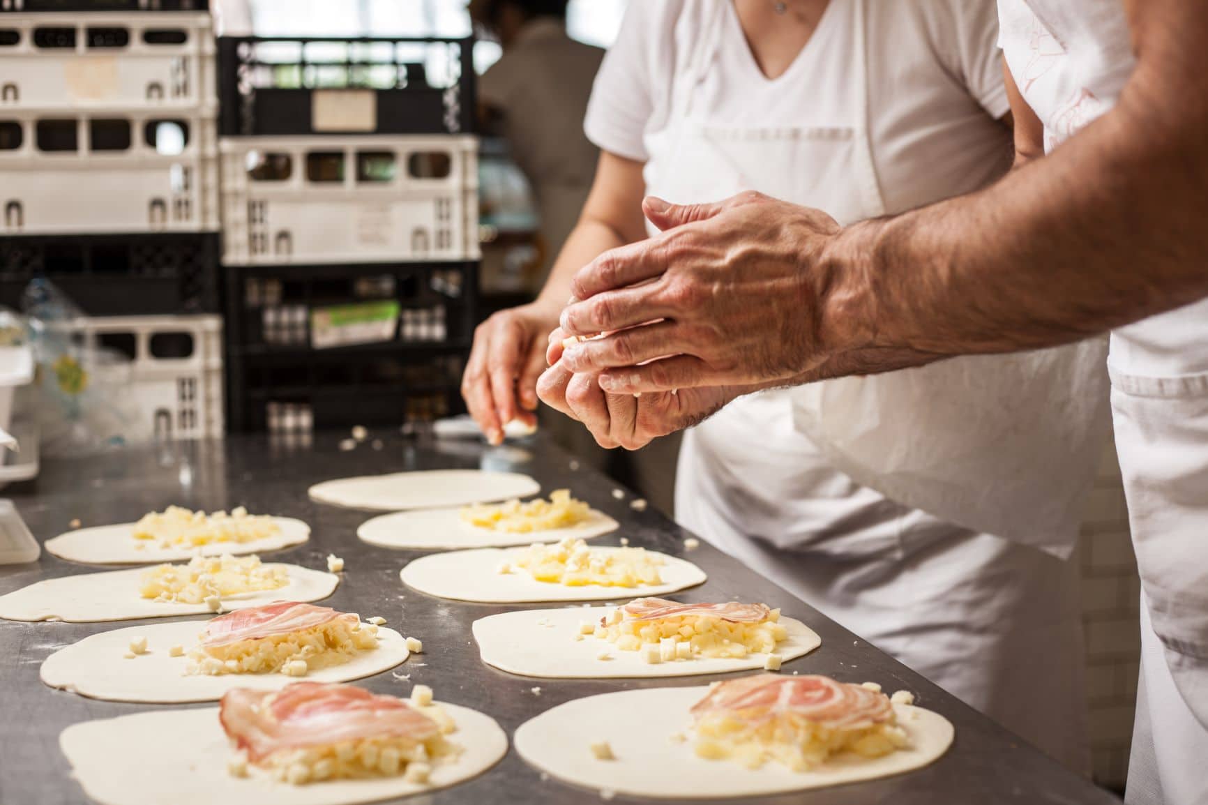 Zwei Köche bereiten mit ihren Händen Piadina zu