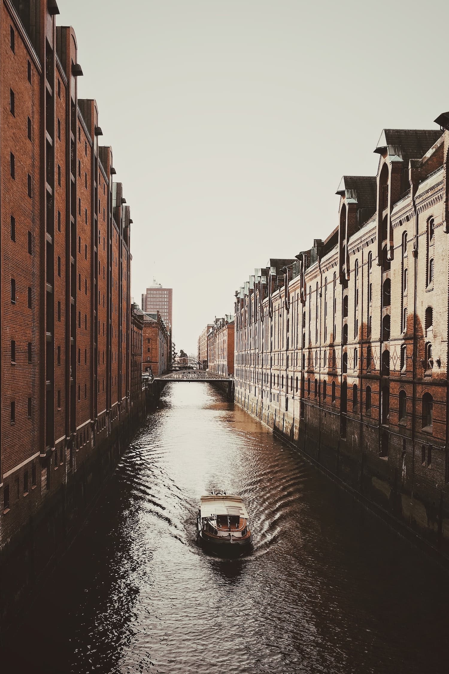 Boot fährt bei Abendstimmung durch die Speicherstadt in Hamburg