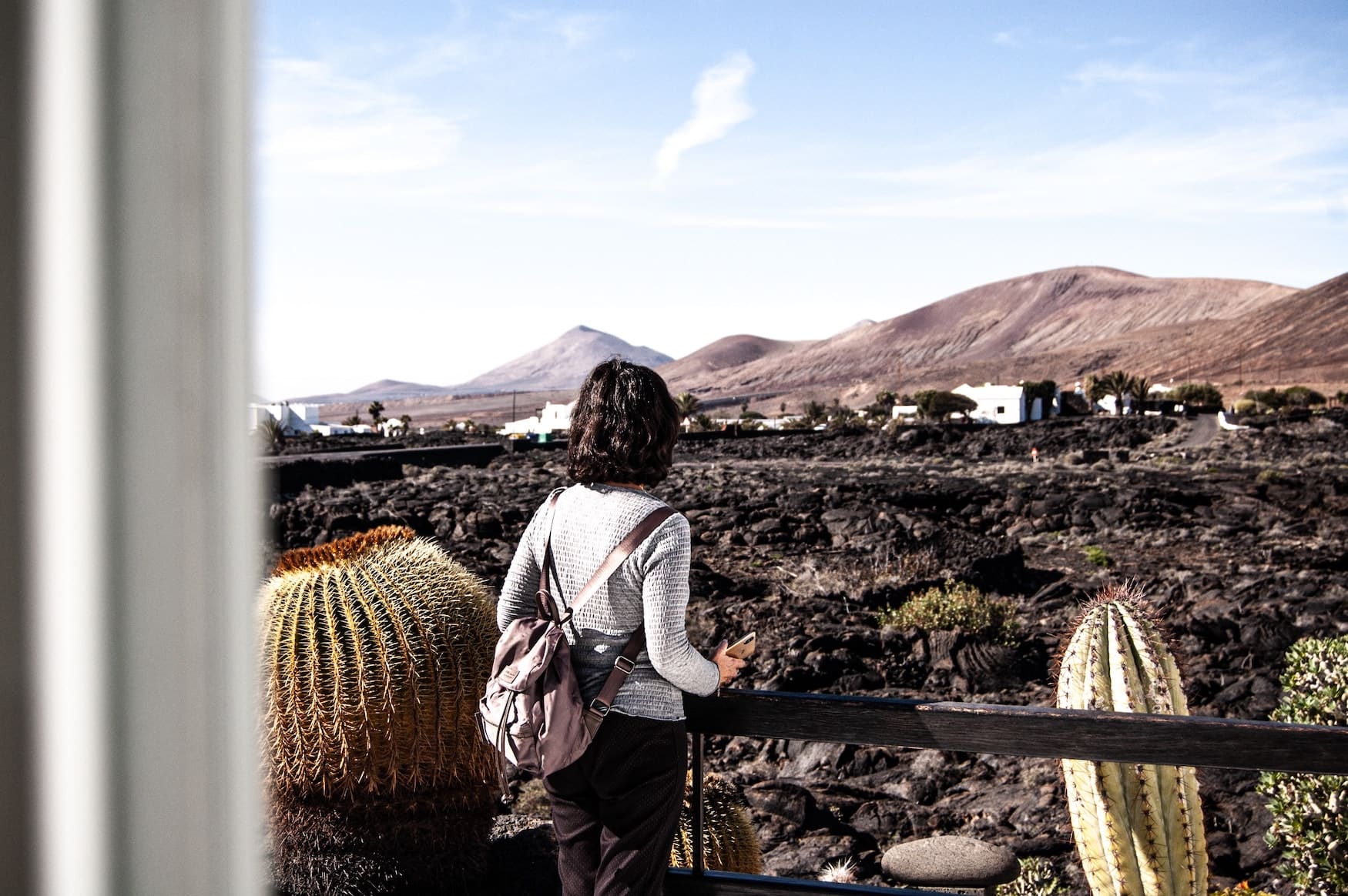 Frau steht in der Cesar Manrique Foundation auf Lanzarote und blickt auf die Kakteenlandschaft
