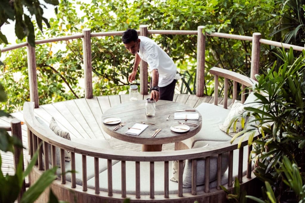 Cempedak Island: Kellner bereitet Tisch fürs Abendessen vor