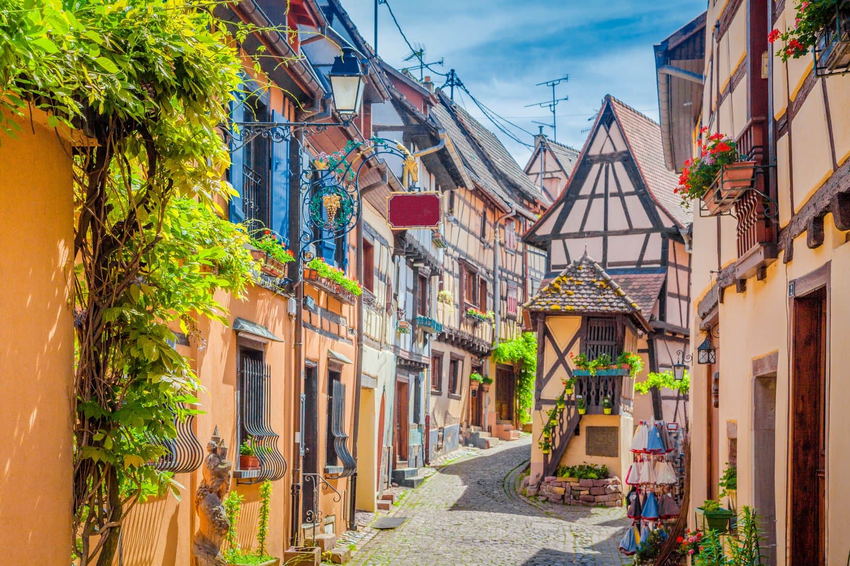 Eine enge Gasse mit buntne Fachwerkhäusern im Weindorf Eguisheim im Elsass 
