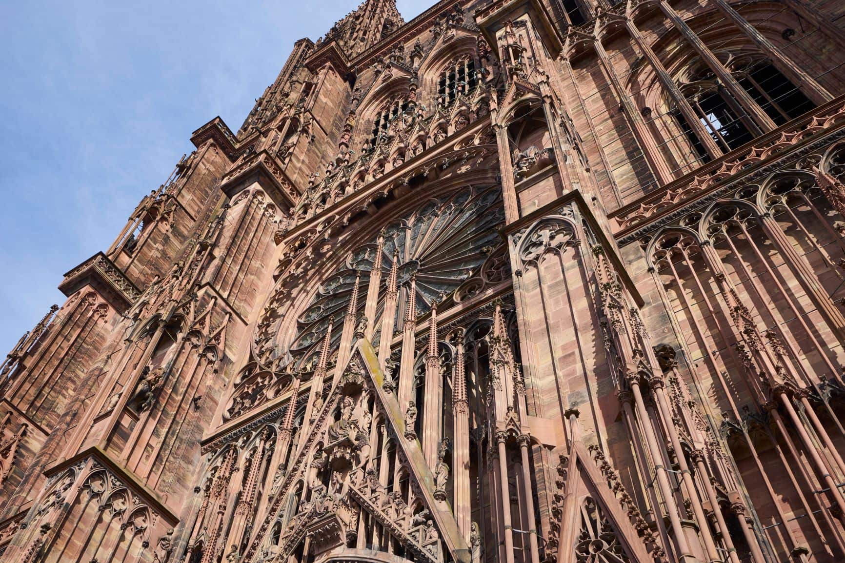 Fassade des Münsters in Straßburg, im Bildfokus steht eine große Fensterrose