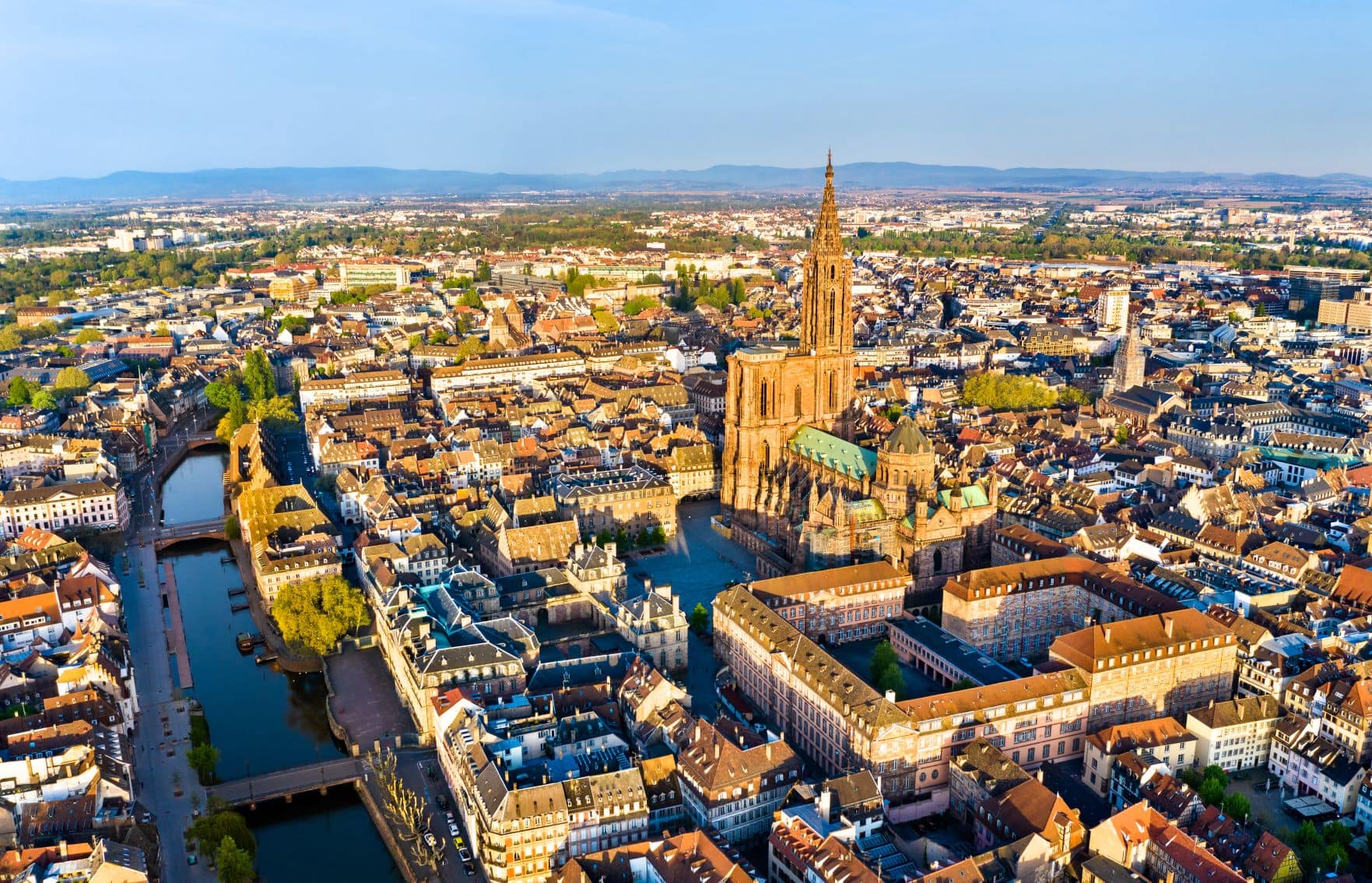 Luftansicht der Altstadt Straßburgs im Sonnenuntergang, promintent in der Mitte das Straßburger Münster