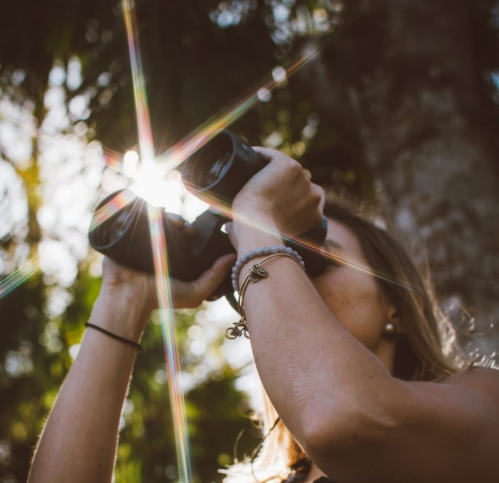 Frau guckt durch Fernglas in Wald