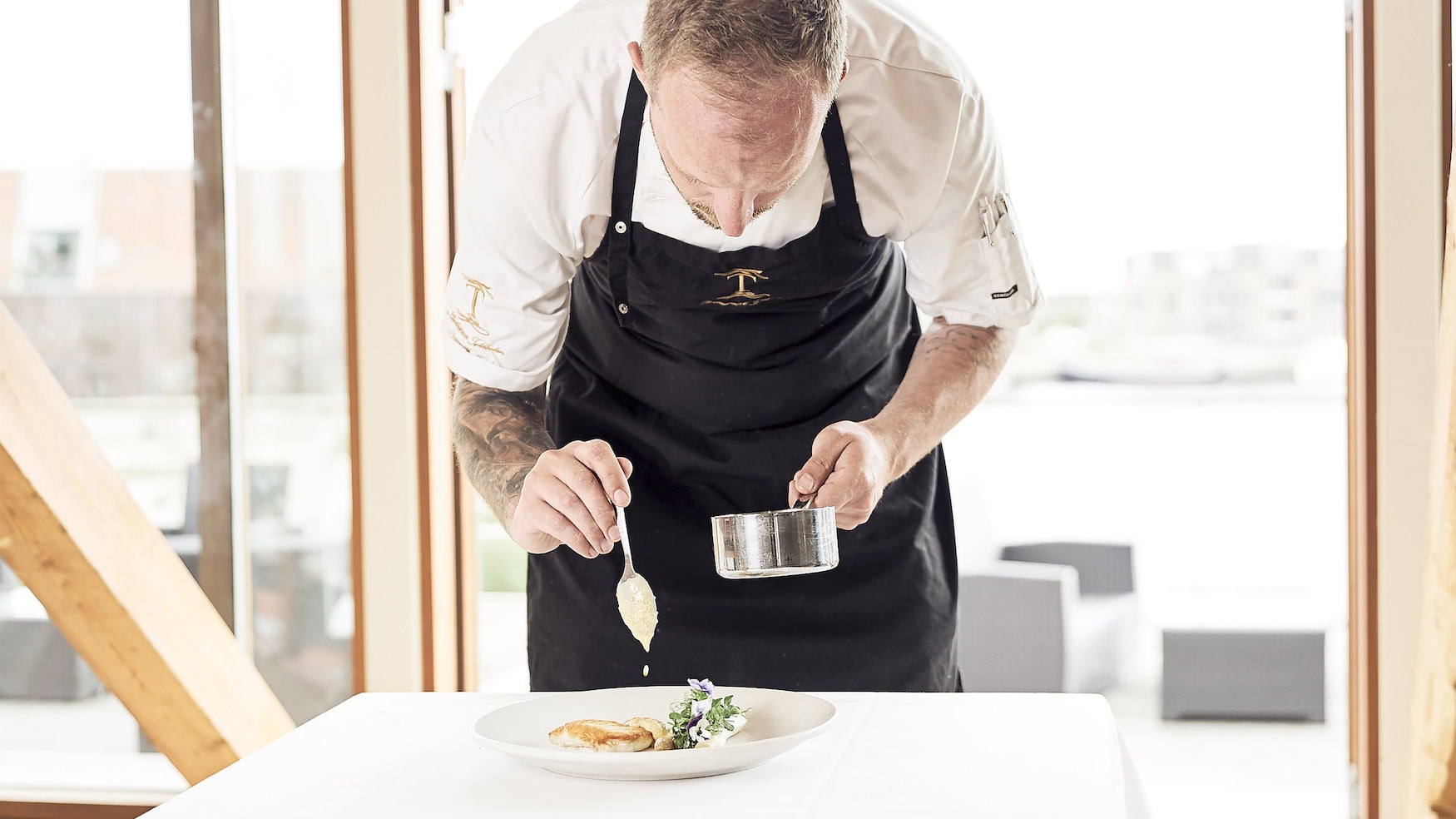 Chefkoch des Restaurants Tolboden richtet einen Teller an.