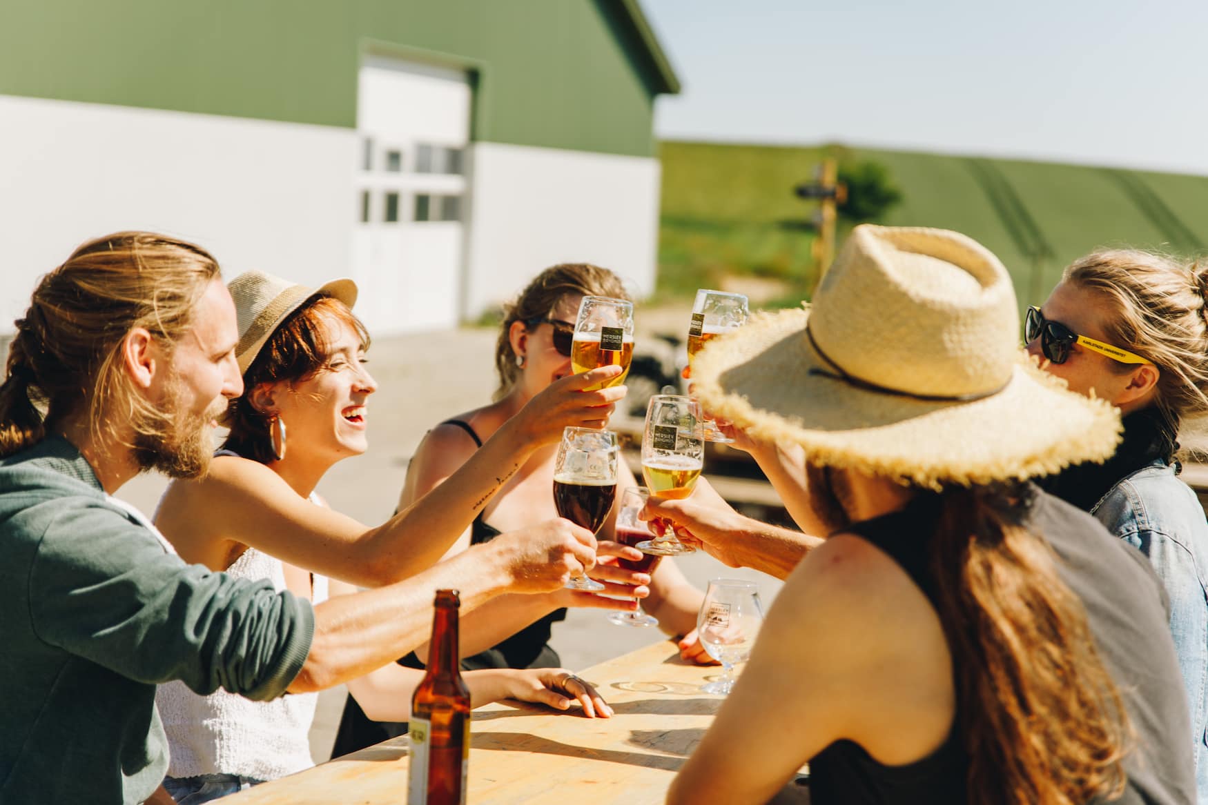Eine Gruppe von Freunden sitzt vor der Herslev Brauerei und prostet sich zu