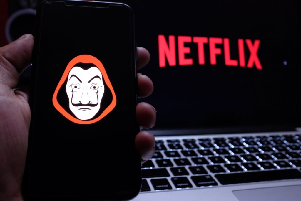 Iphone Maske Casa de Papel, im Hintergrund Notebook mit Neflix-Logo