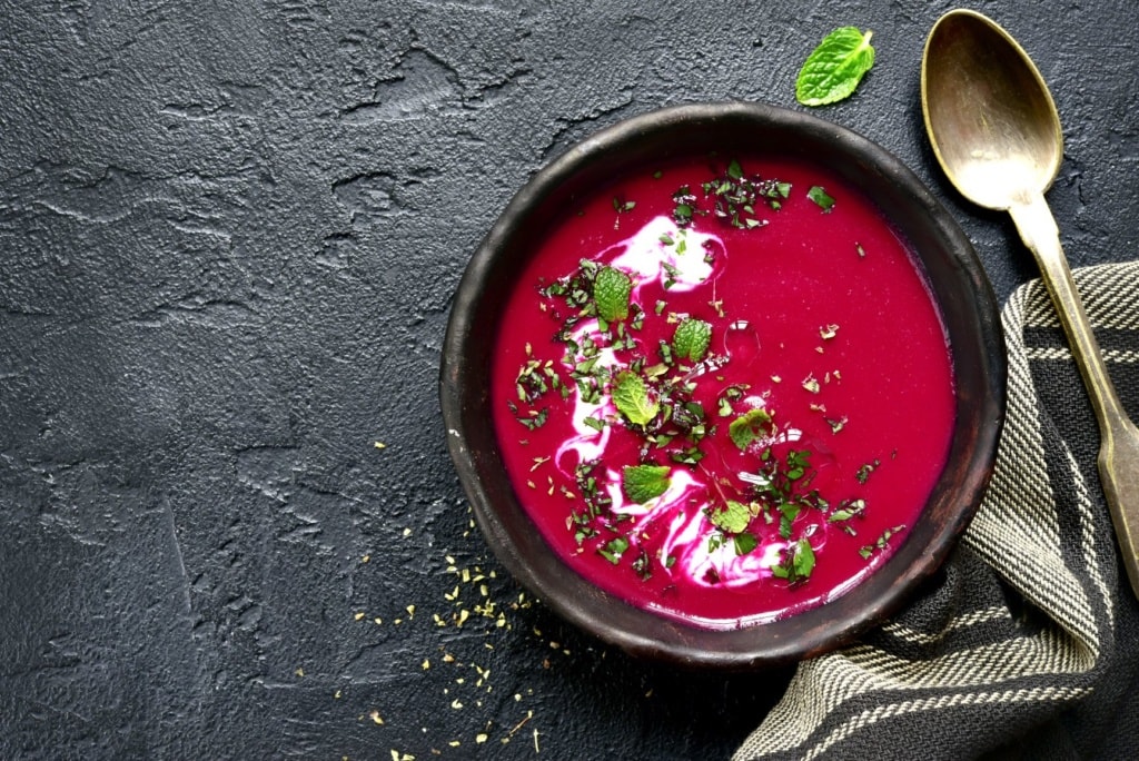 Rote-Beete-Suppe auf schwarzem Tisch-Untergrund 