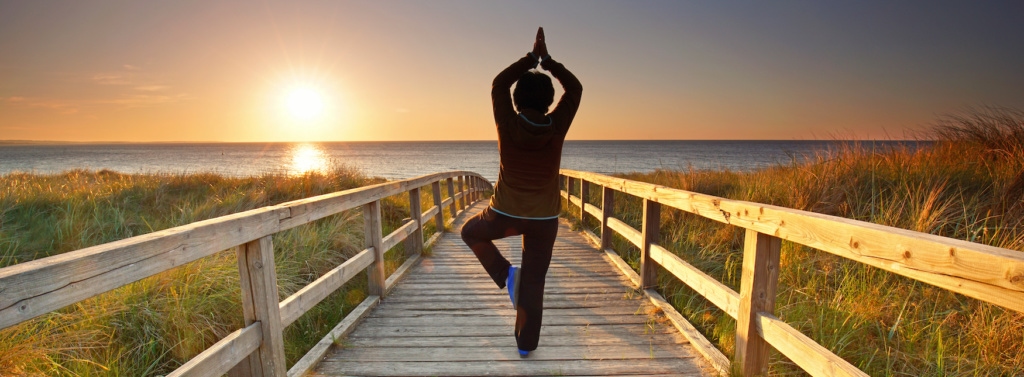 Frau beim Yoga auf Rügen während Sonnenuntergang