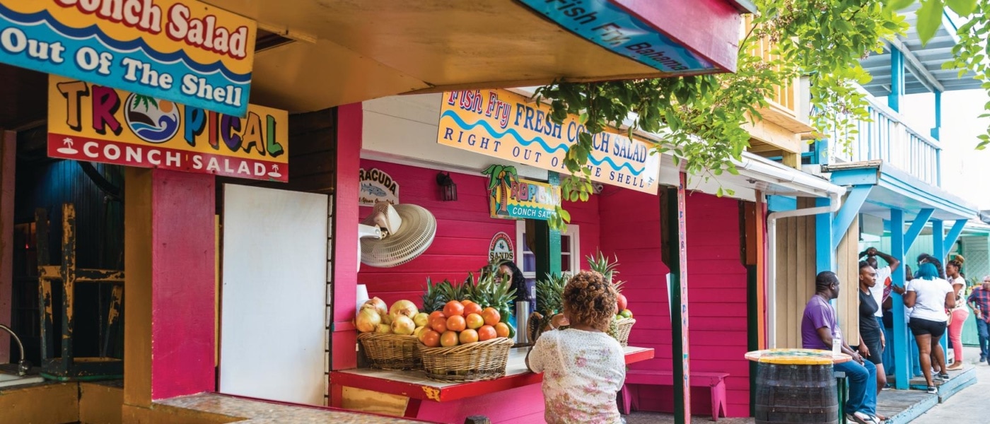 Frau sitzt an Fish Fry, einem Imbiss-Stand auf den Bahamas