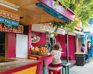 Frau sitzt an Fish Fry, einem Imbiss-Stand auf den Bahamas