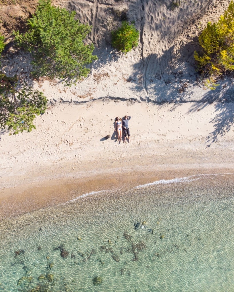 Drohnenaufnahme eines Pärchens am Strand
