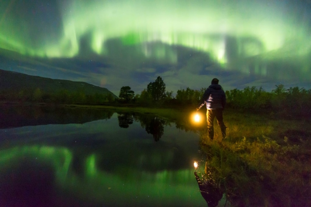 Mann am See, der Polarlichter beobachtet