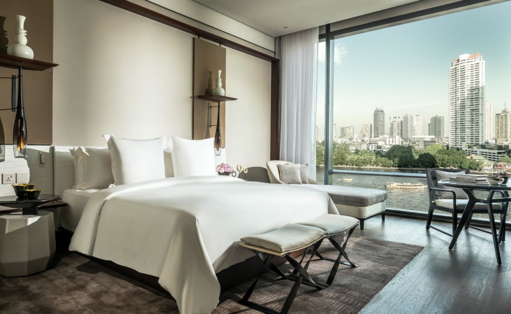 Bett im Hotelzimmer in Bangkok mit Blick auf den Fluss