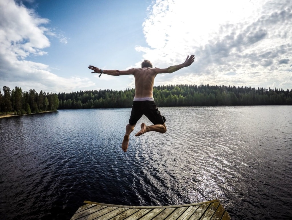 Junger Mann springt in einen See