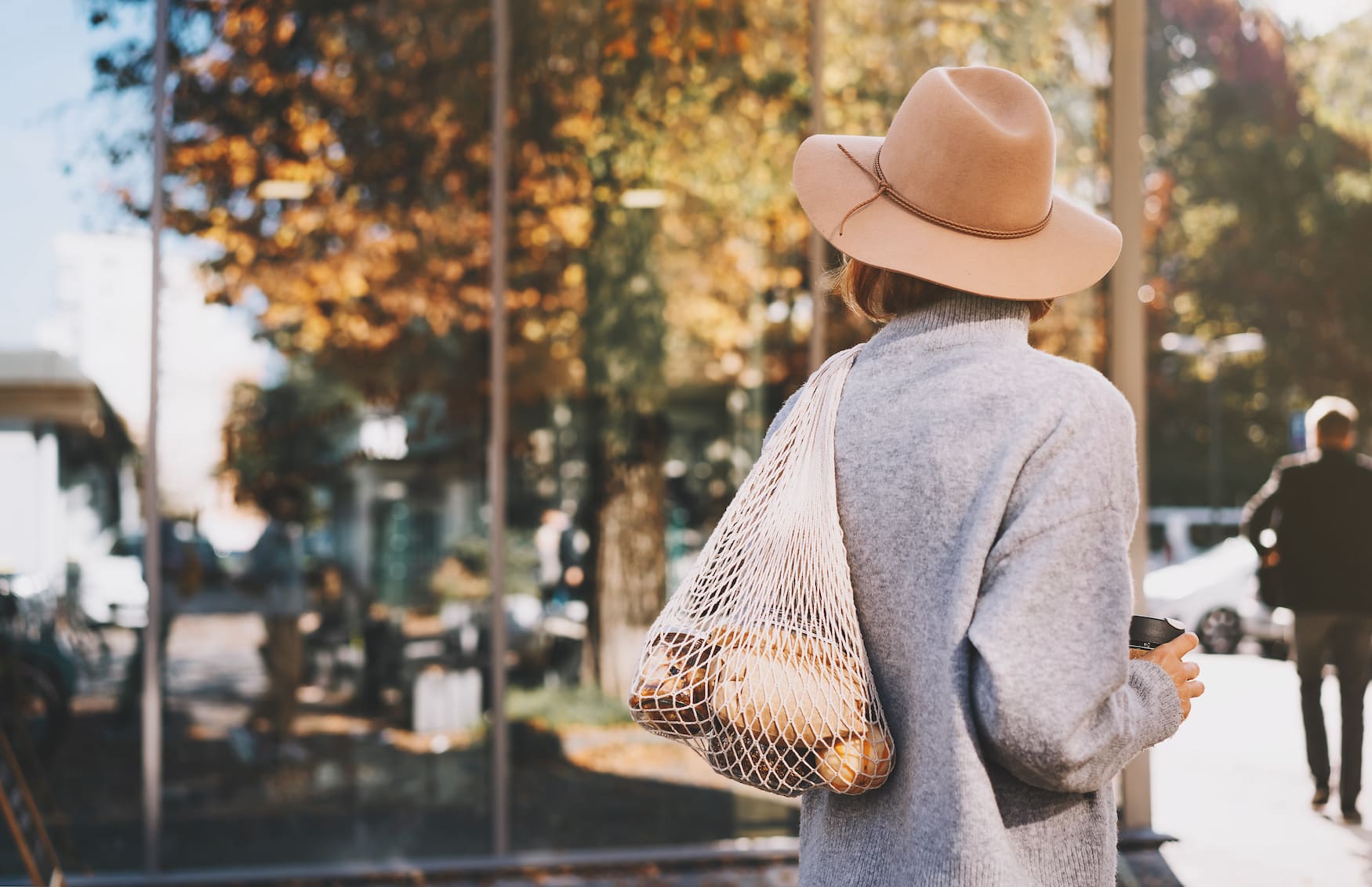 Frau spaziert mit Zero-Waste-Beutel durch Ljubljana