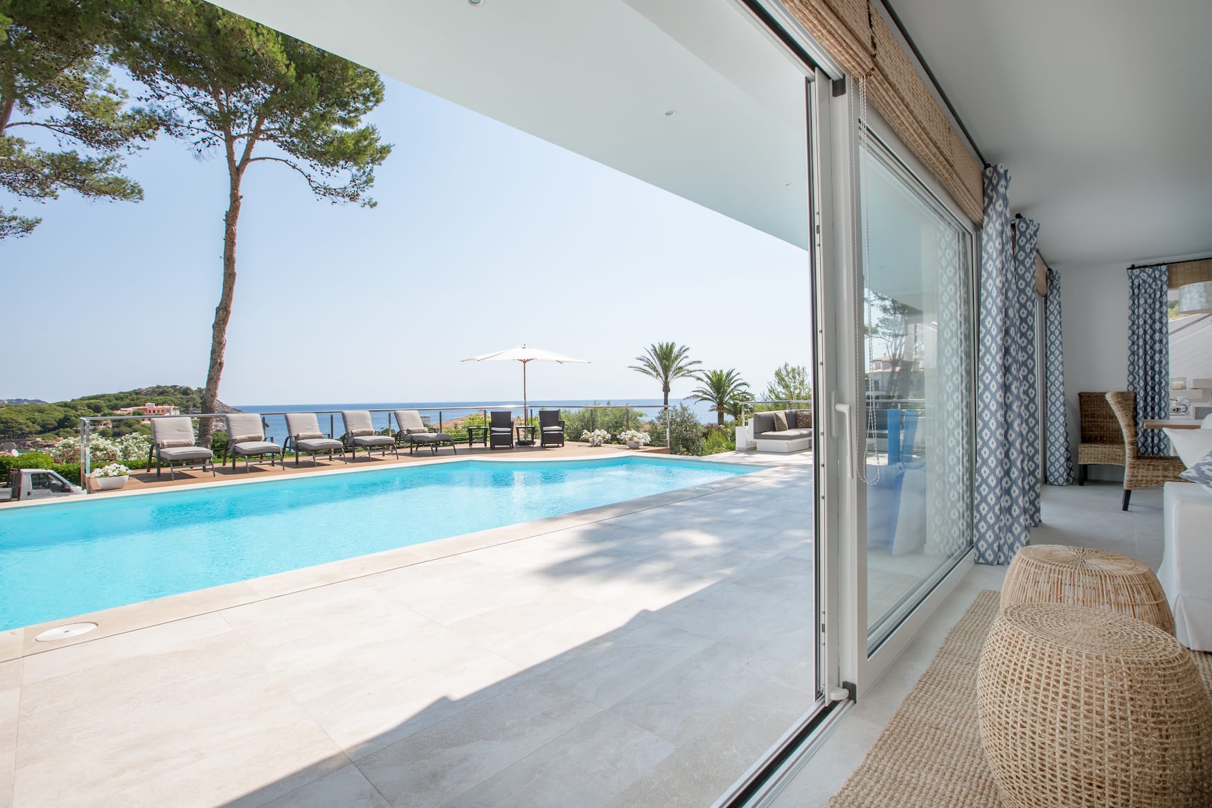 Blick aus dem Wohnraum der Brisa Marina, einem Ferienhaus auf Mallorca, auf den Pool und den dahinterliegende Ozean