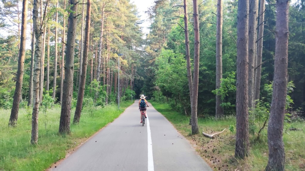 Frau auf einem Fahrradweg im Wald