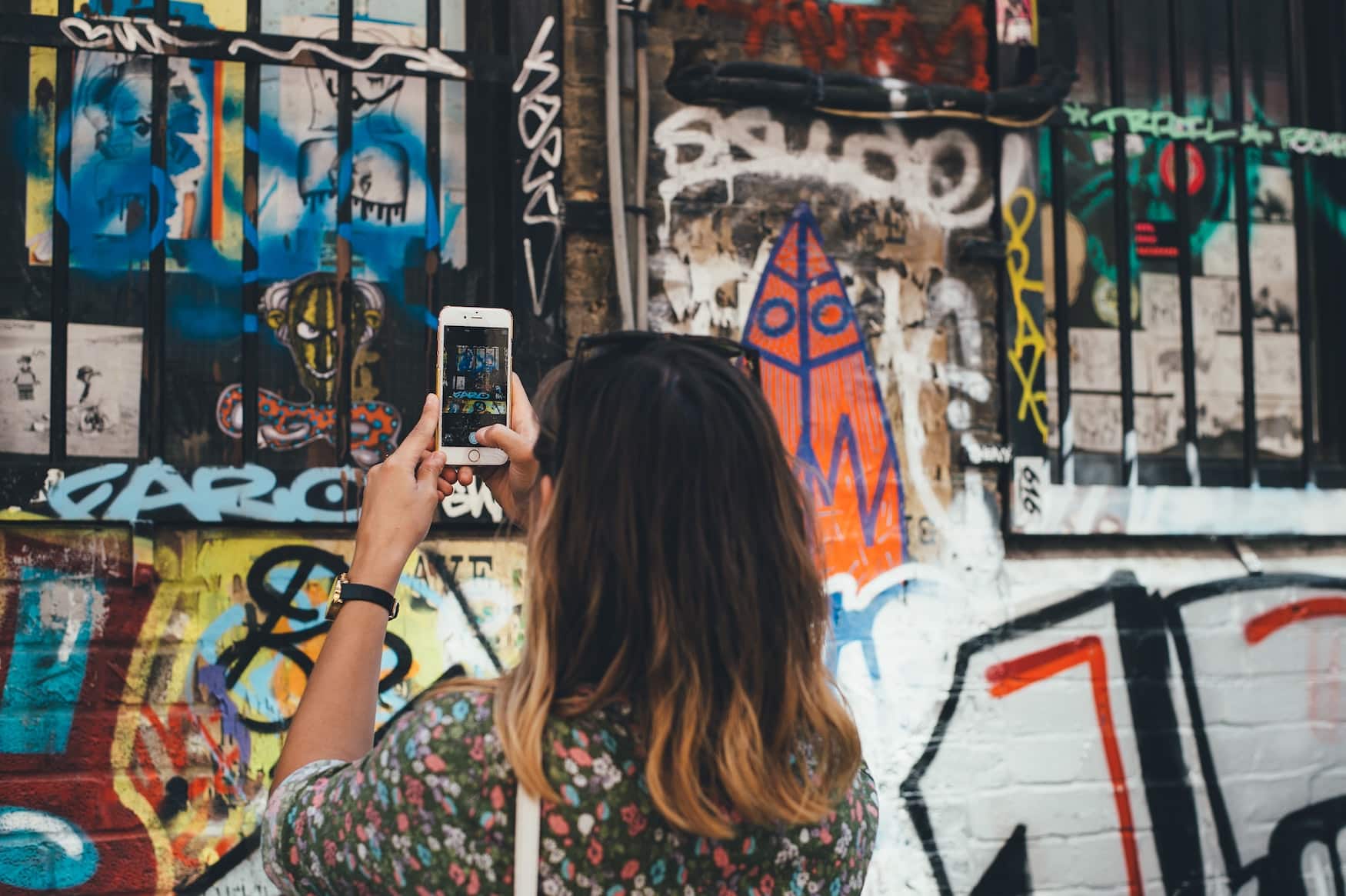 Junges Mädchen fotografiert Street Art in Shoreditch, London