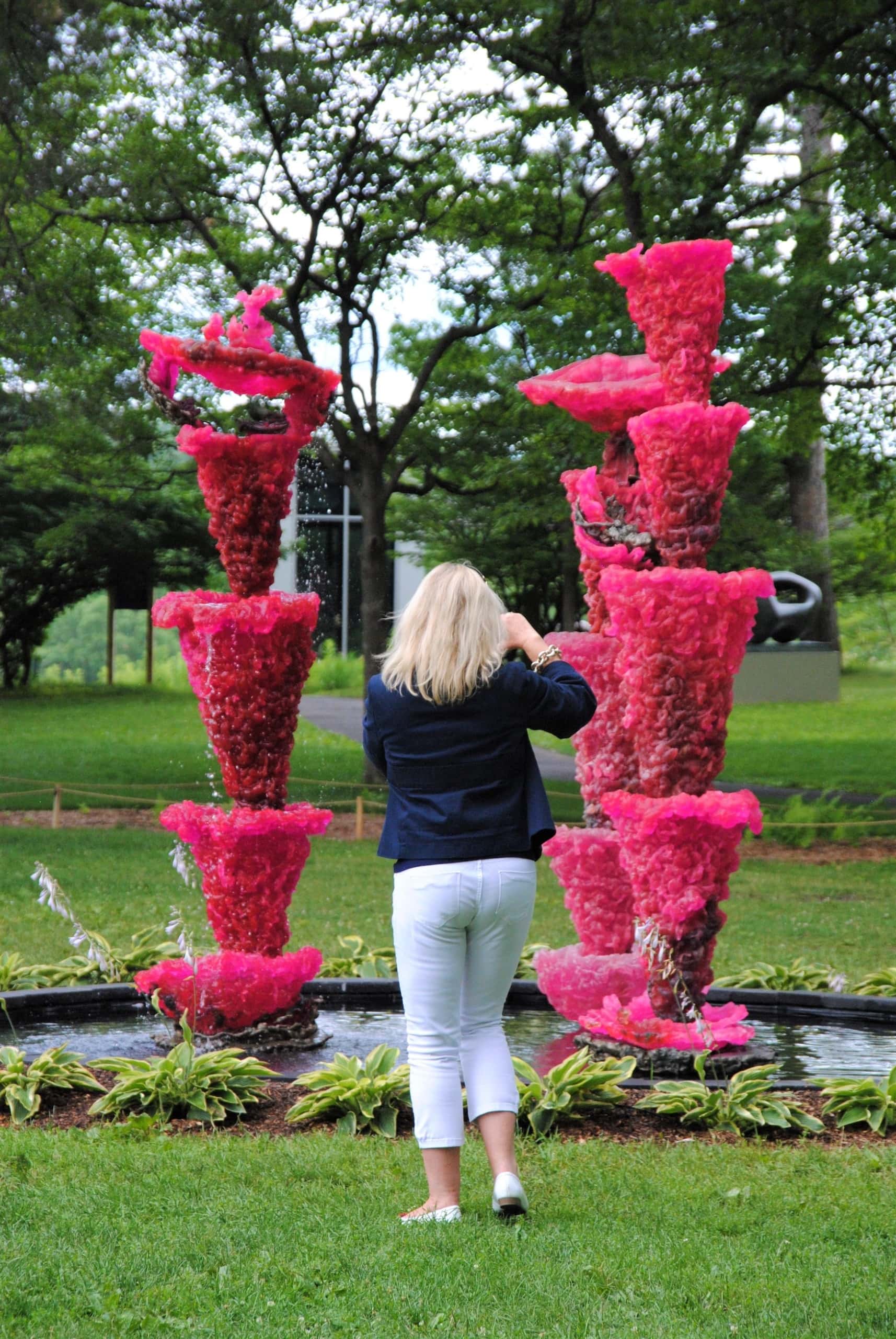 Besucherin fotografiert pinke Skulptur im Storm King Art Centre