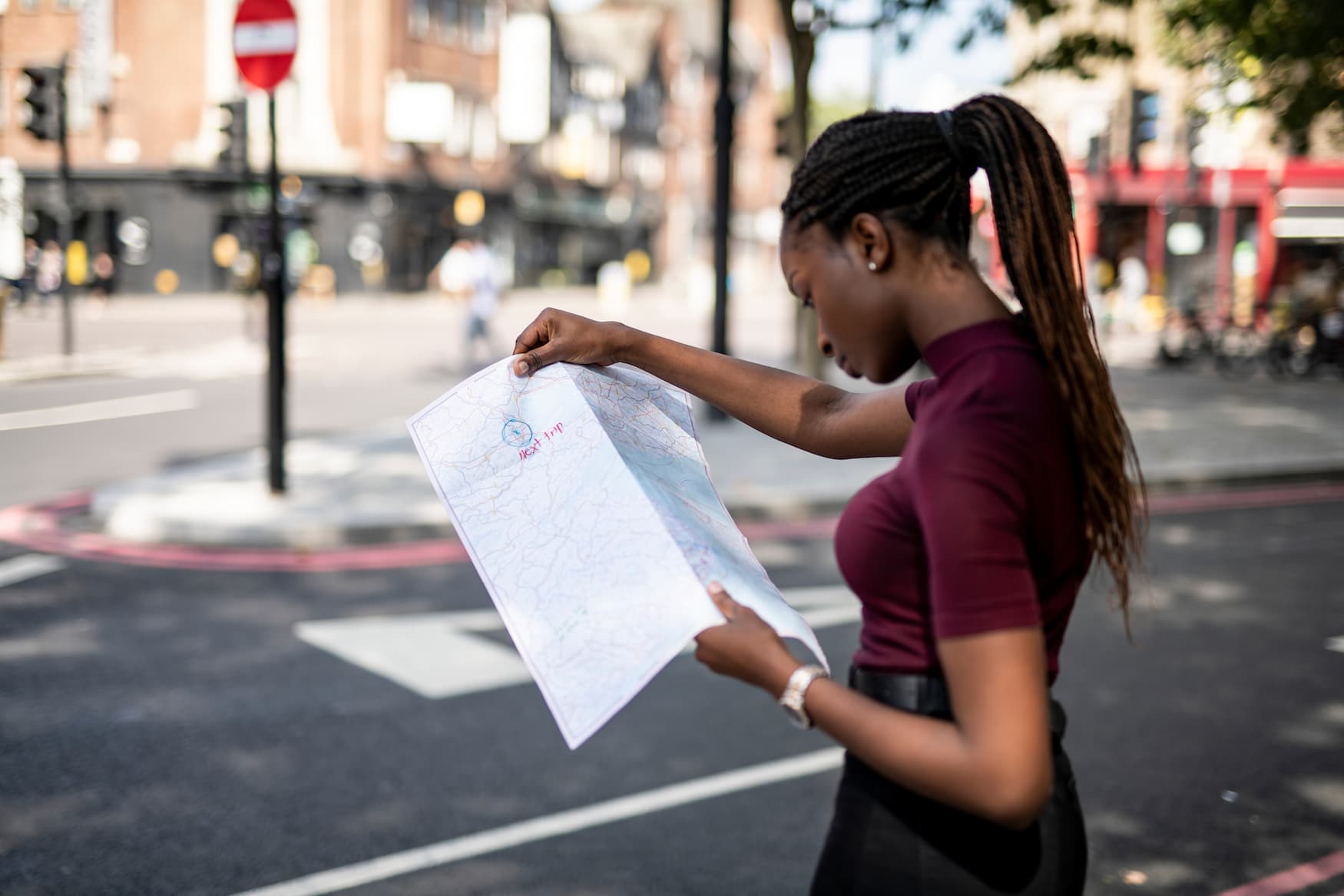 Schwarze Touristin liest Straßenkarte in London, da sie alleine reist