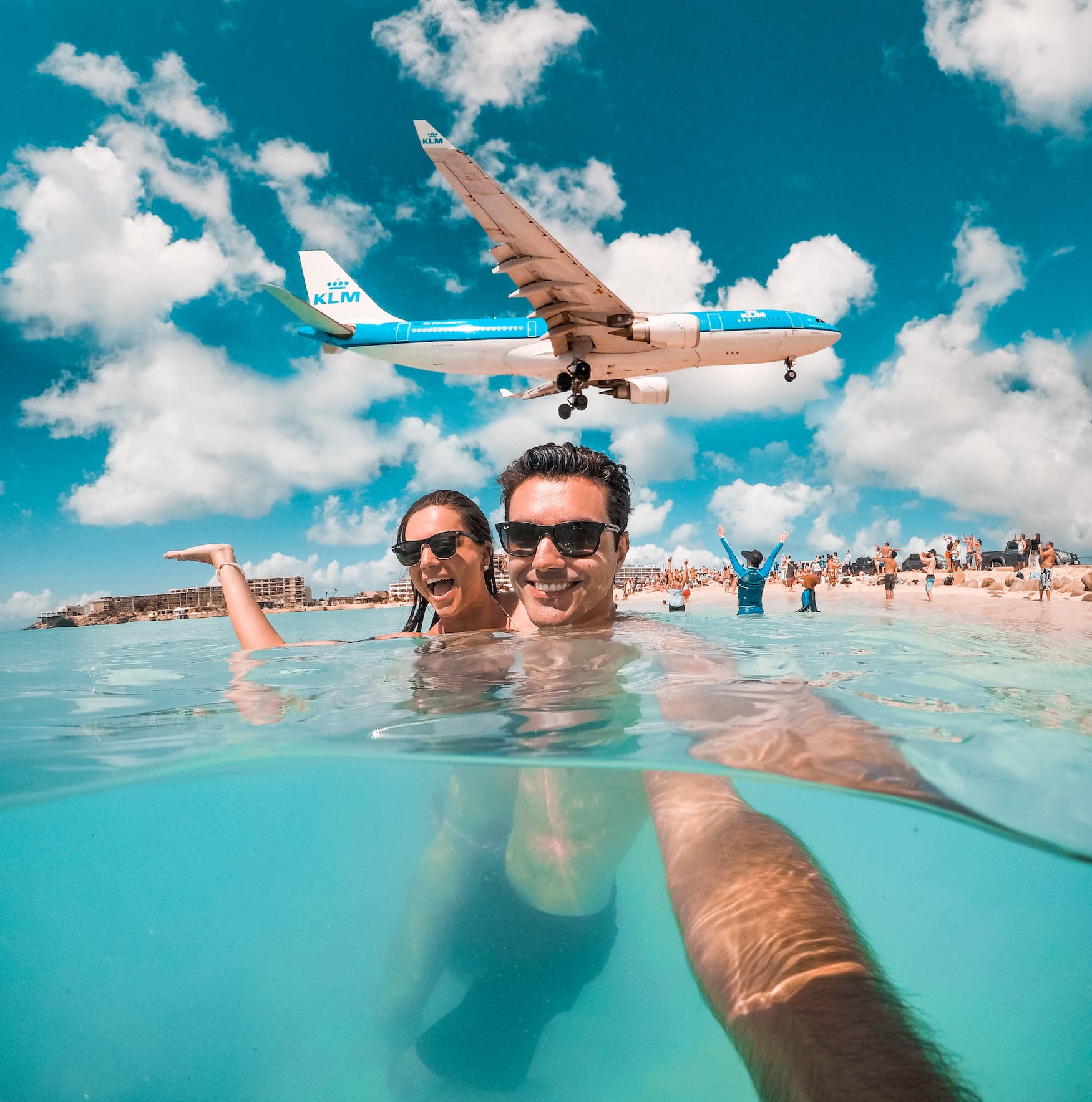 Pärchen macht Selfie am Maho Beach in Sint Marteen, mit Flugzeug über den Köpfen