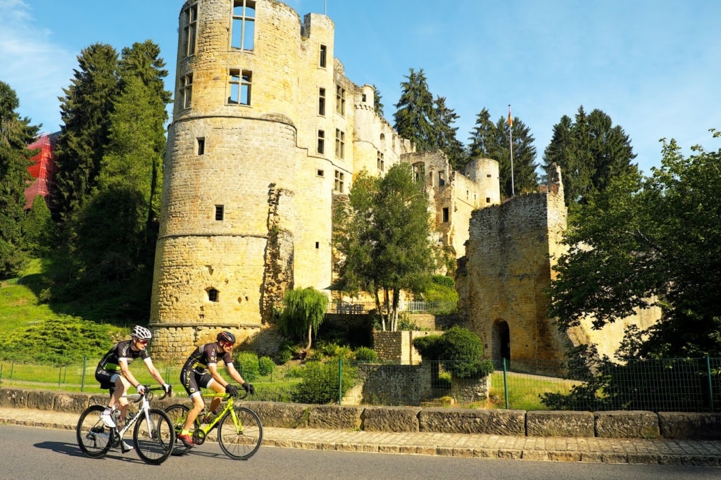 Radfahrer vor Schloss Beaufort in Luxemburg
