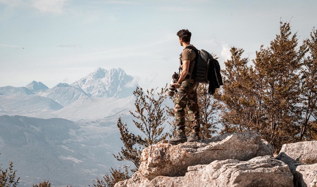 Fotograf steht auf einem Felsen und genießt die Aussicht über den Nationalpark Majella in den Abruzzen
