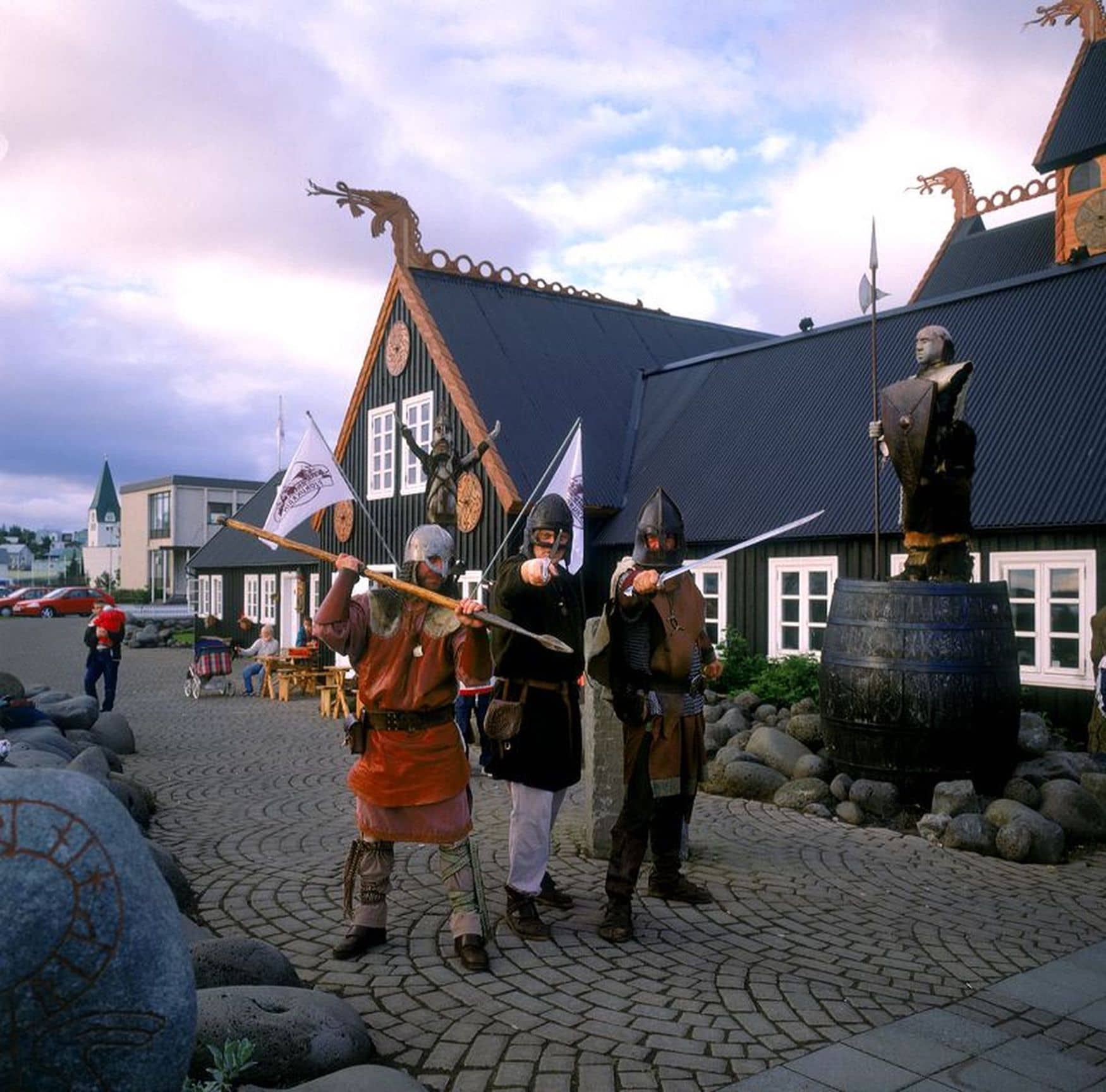 Menschen stehen als Wikinger verkleidet vor einem Wikingerhotel