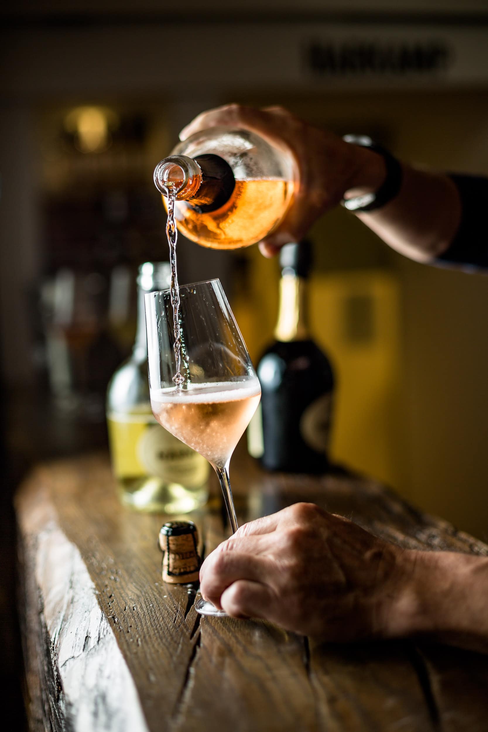 Mann schüttet Sekt in Glas