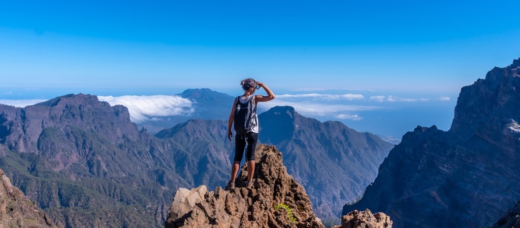 Junge Frau beim Wandern auf den Kanarischen Inseln überblickt die Landschaft an der Caldera de Taburiente auf Lanzarote