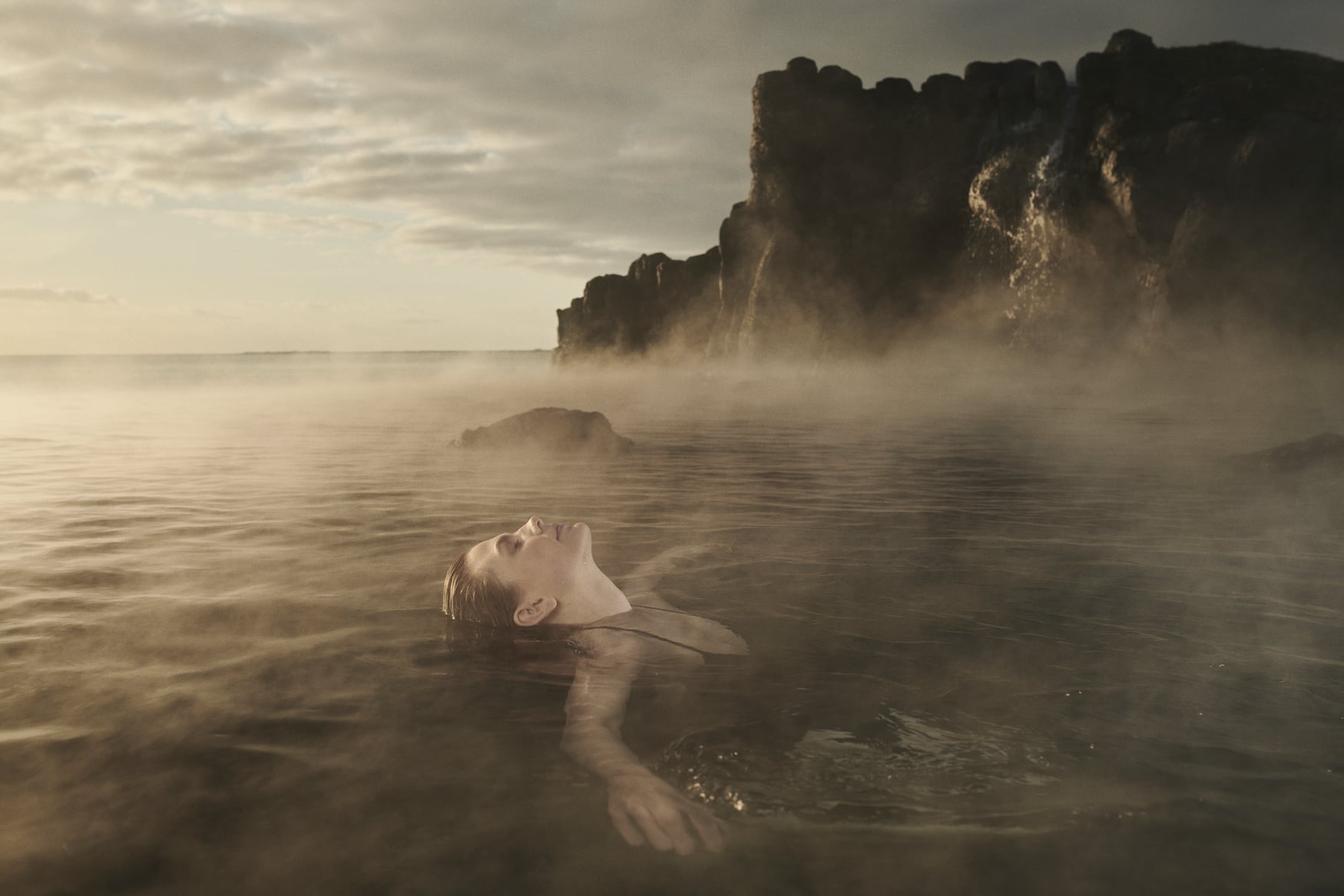 Frau entspannt in Thermalbecken der Sky Lagoon