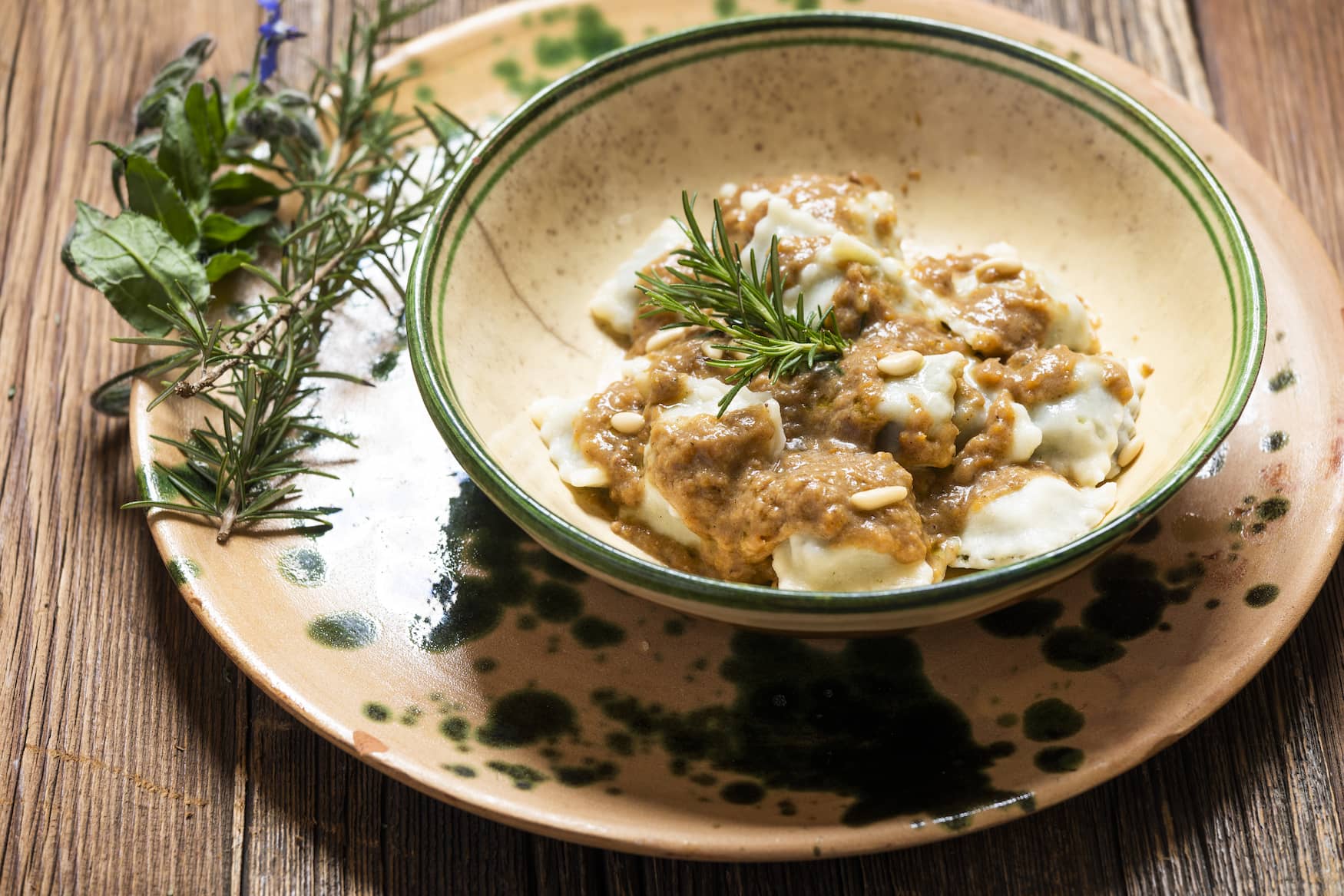 Ravioli mit Fleischsoße, gewürzt mit Kräutern, Pilzen und Pinienkernen