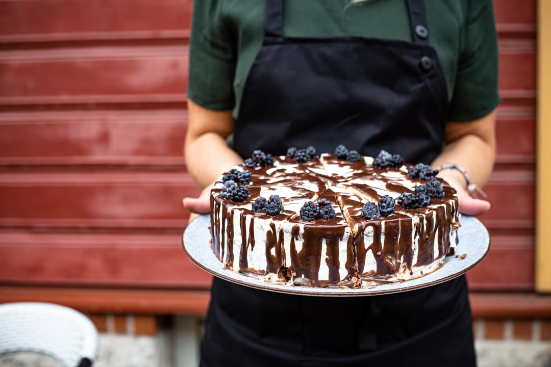 Frau hält Kuchen in beiden Händen 