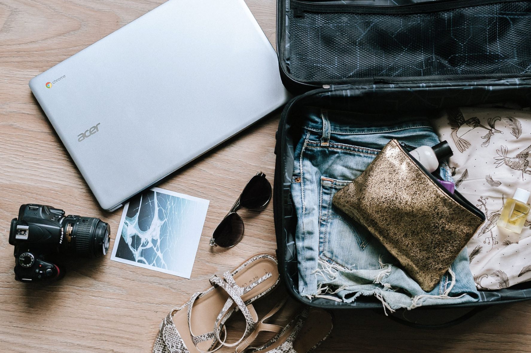 Kleiner gepacker Koffer, Fotoapparat und Notebook
