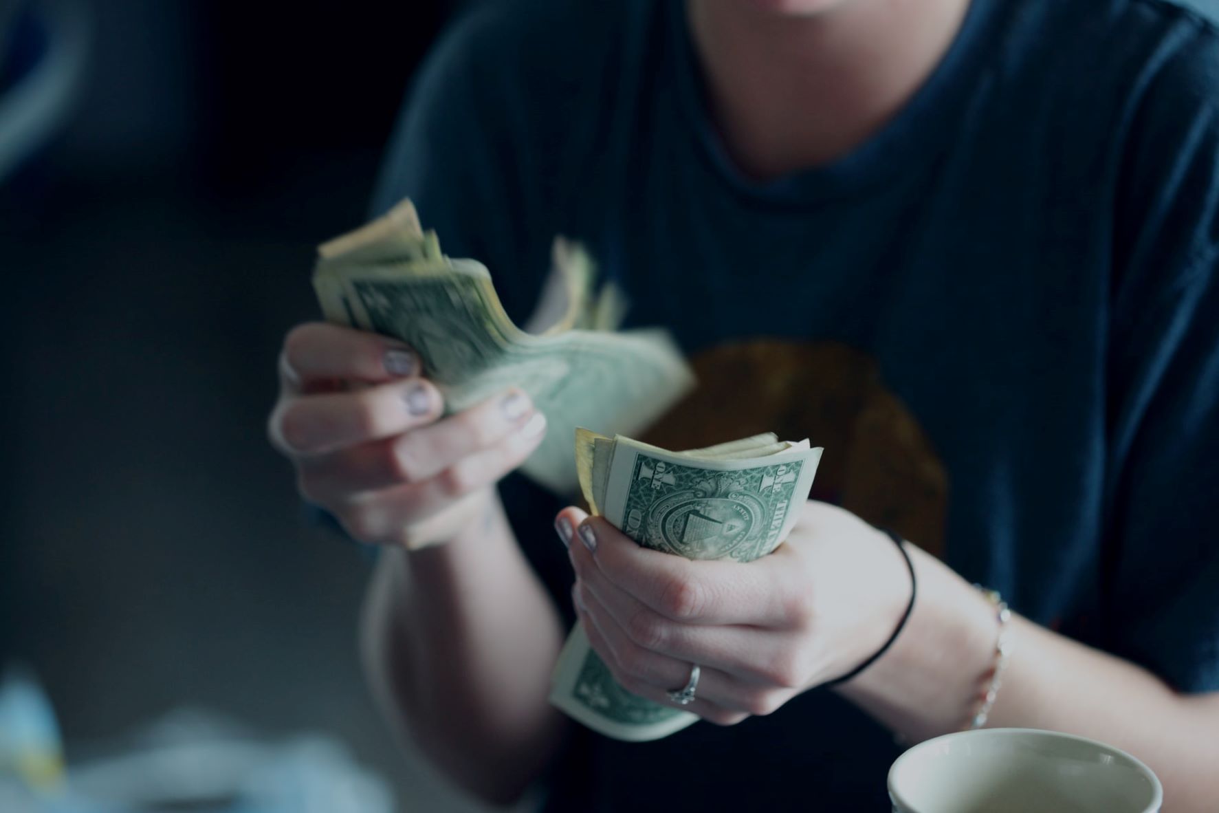 Frau zählt Dollar-Scheine