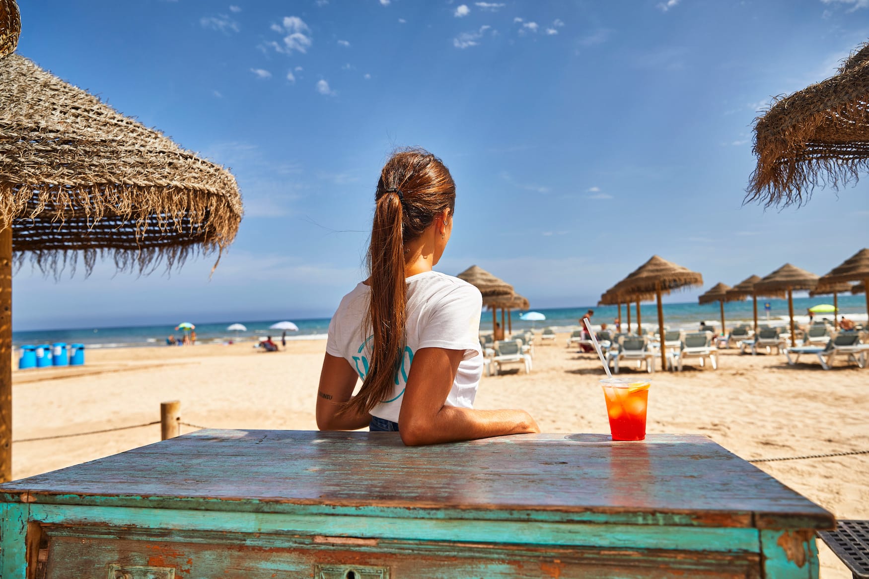 Frau sitzt am Strand in Valencia