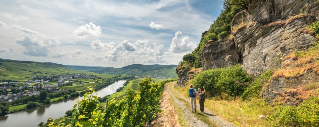 Wanderer auf dem Moselsteig bestaunen Felsmassiv und Weitblick über das Moseltal