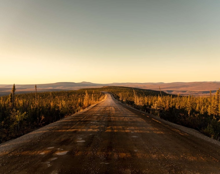 Straße führt durch kanadische Landschaft bei Dämmerung