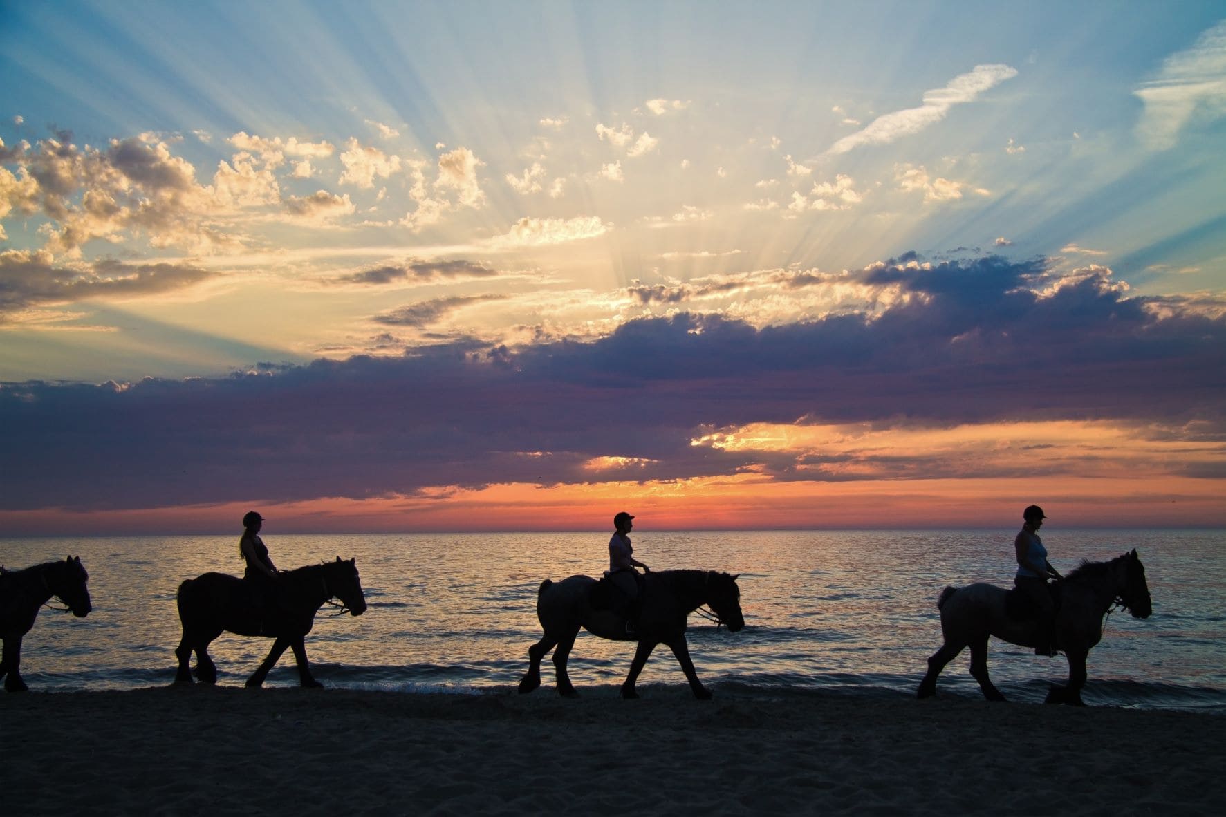 Gruppe von Reitern am Strand