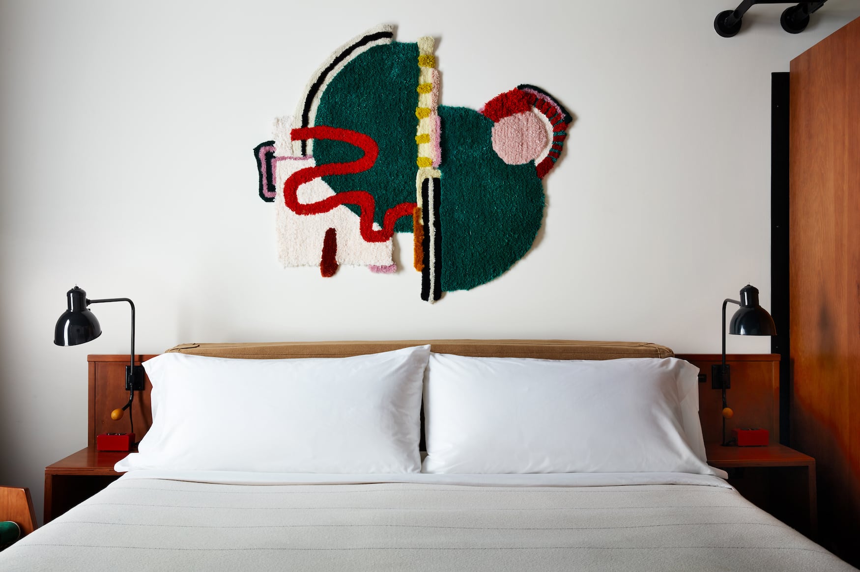 Kunst hängt über Bett im Hotelzimmer des Ace Hotel Brooklyn