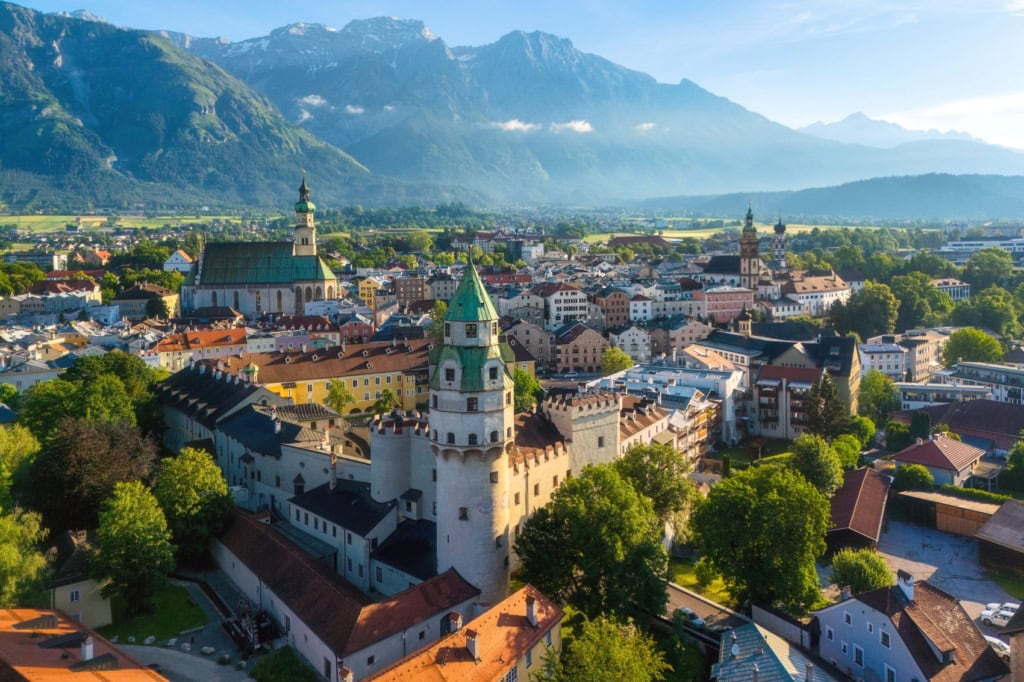 Panorama von Innsbruck im Sommer: Im Vordergrund die Stadt, hinten die Berge.