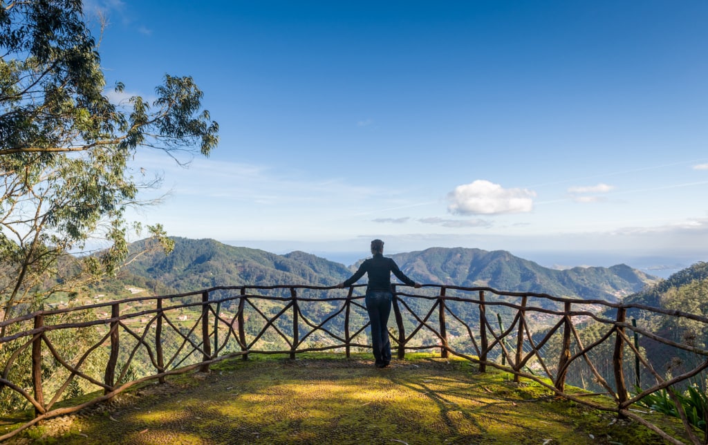 Frau betrachtet die Berglandschaft vom Aussichtspunkt des Parks Santo da Serra. Insel Madeira, Portugal.
