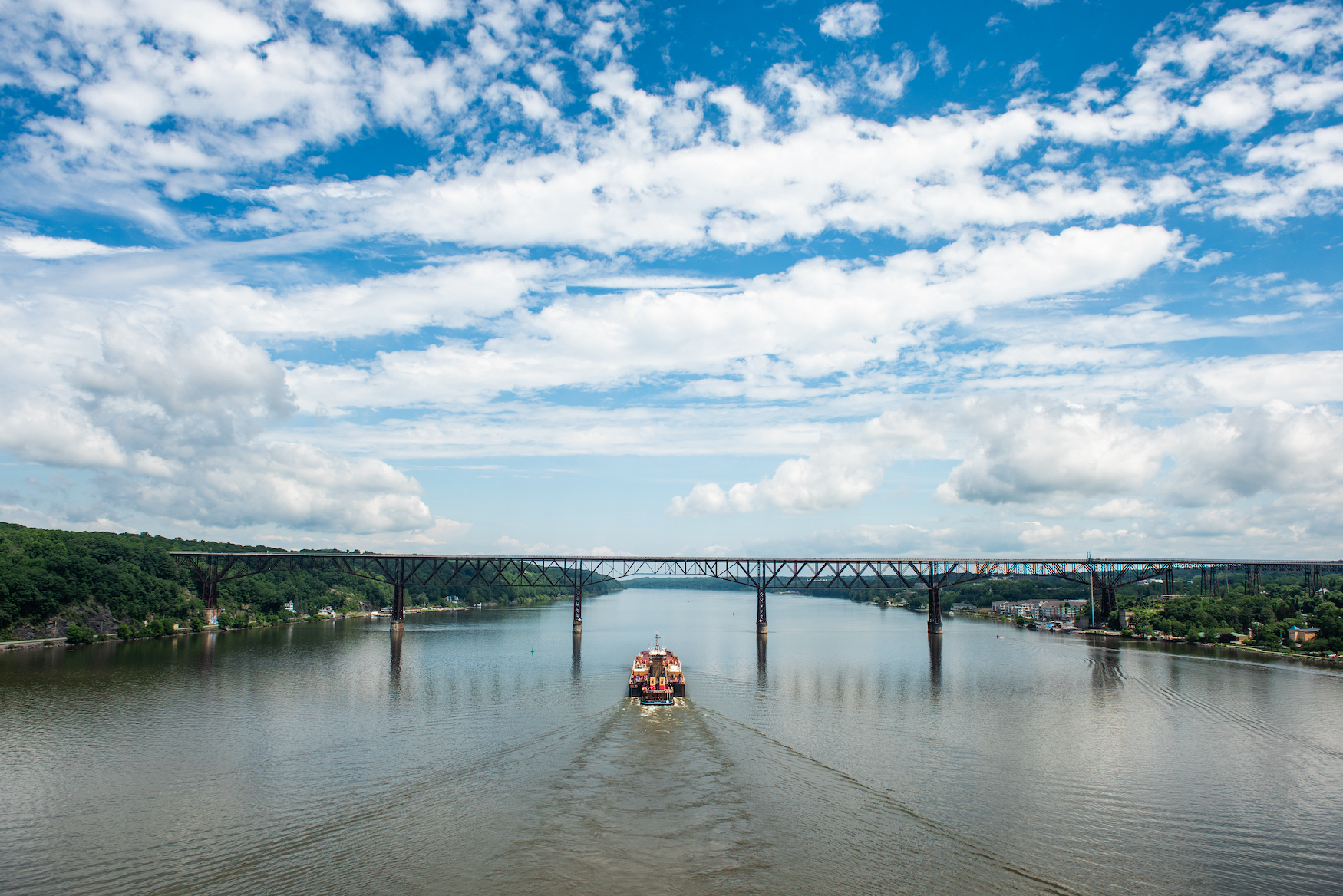 Containerschiff fährt durch Eisenbahnbrücke in Poughkeepsie